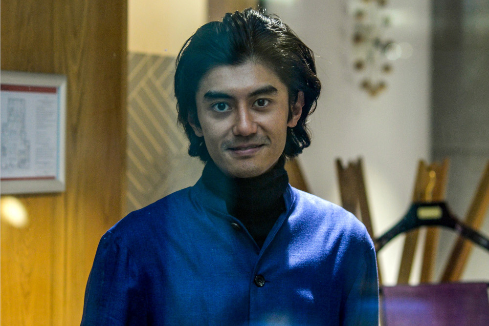A man wearing a blue bamboo shirt over a blank polo-neck